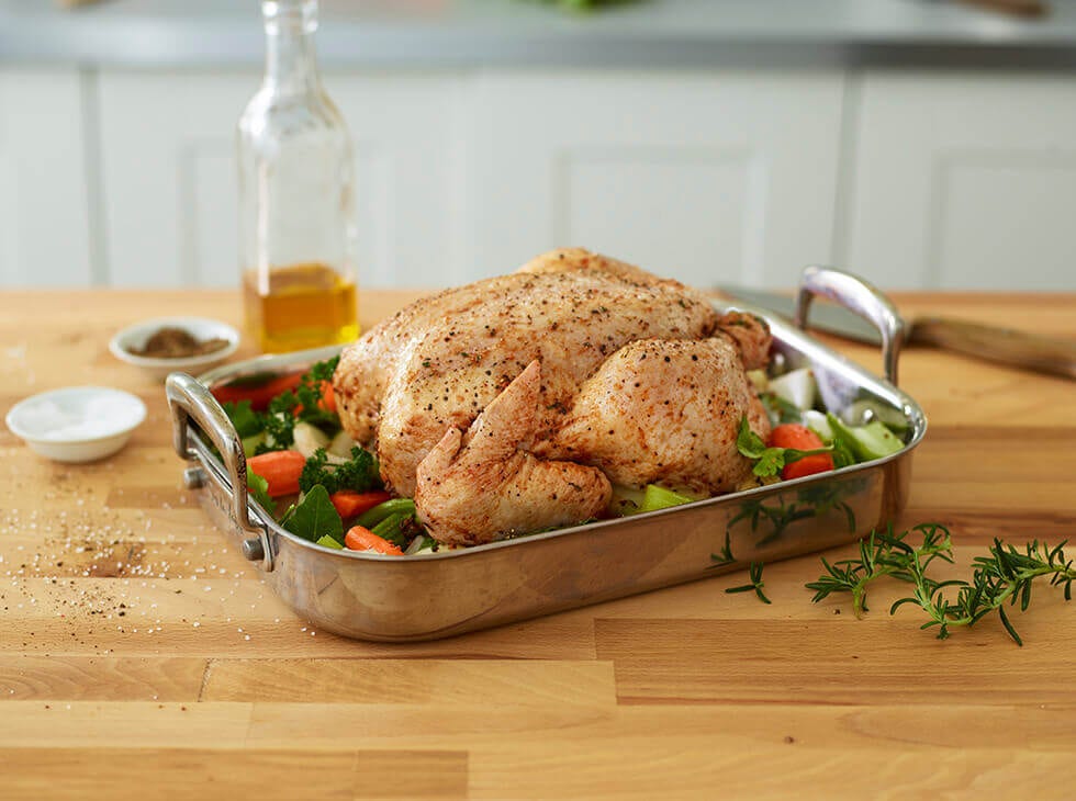 Cooked whole bird in a tray with vegetables 