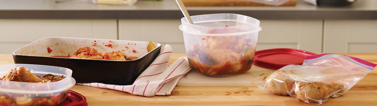 Prepping and storing chicken in containers on kitchen counter