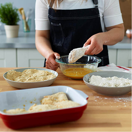 Preparing hand breaded chicken in flour and egg wash