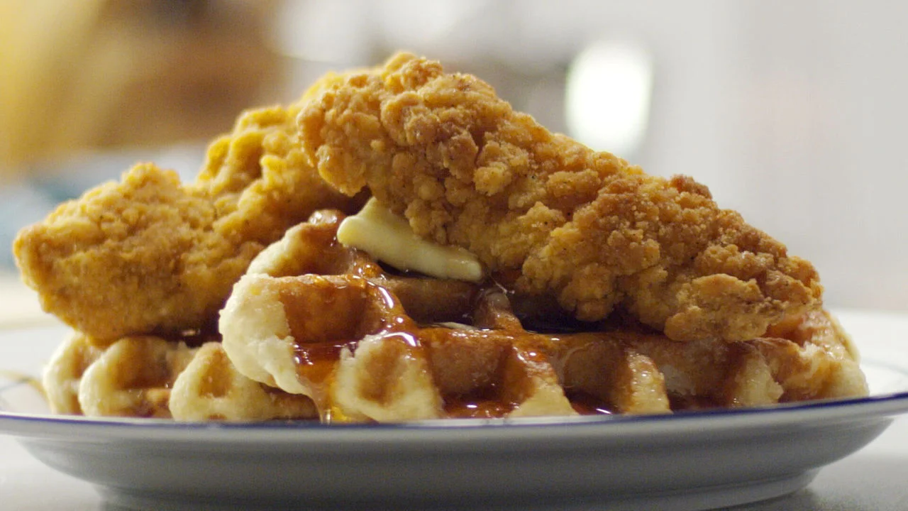 Savory crispy chicken strips layered over caramelized onion waffles