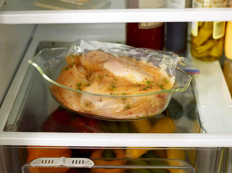 Chicken being marinated in a ziplock bag