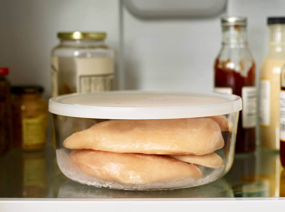 Chicken in a glass container thawing