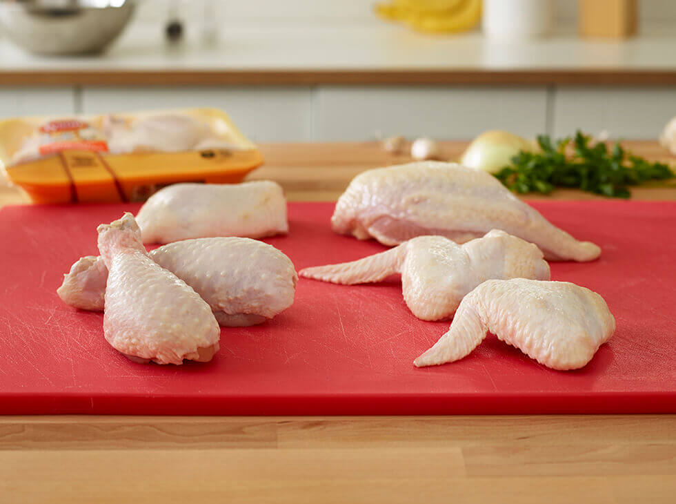 Raw chicken on a red cutting board
