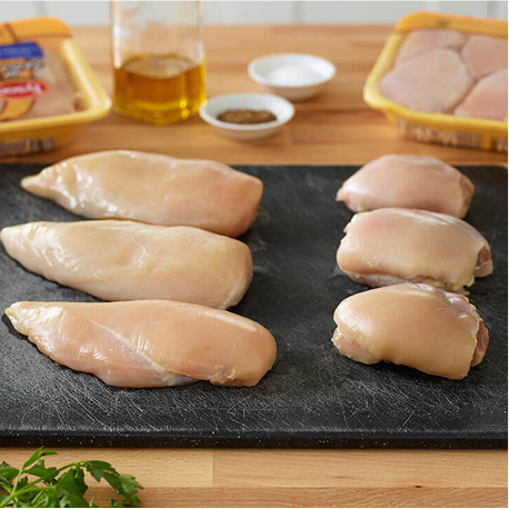 Raw Tyson chicken breast and thighs on cutting board